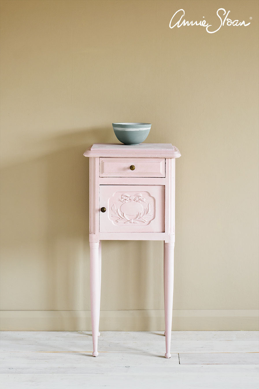 Vintage side table painted in Annie Sloan Antoinette Pink Chalk Paint against a wall painted in Old White Wall Paint