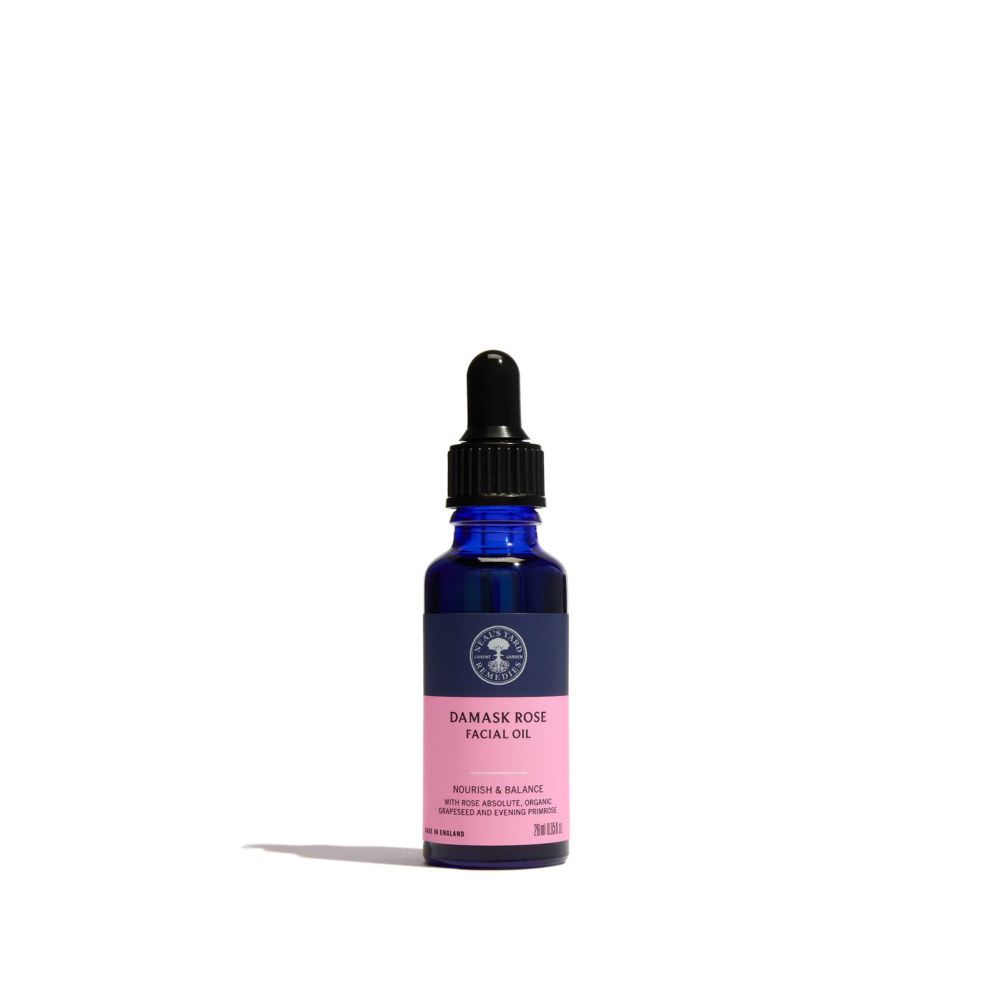 Damask Rose Facial Oil from Neal's Yard Remedies in a cobalt blue glass dropper bottle with a black cap and a pink label, set against a plain white background.