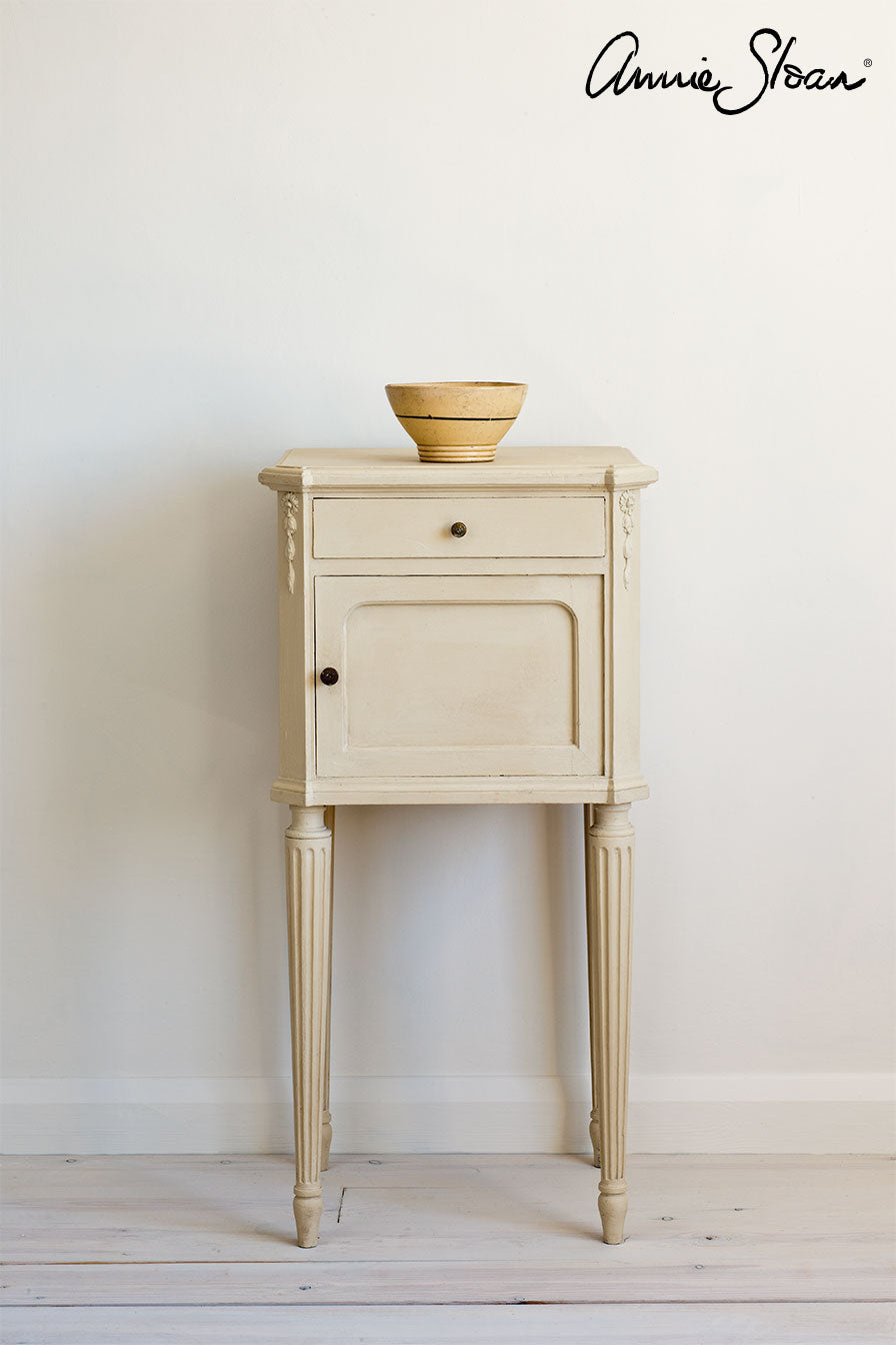 Small wooden side table painted with Annie Sloan Old Ochre Chalk Paint against wll painted with Old White Wall Paint